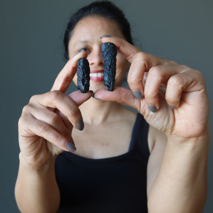 sheila of satin crystals holding rough black tektites