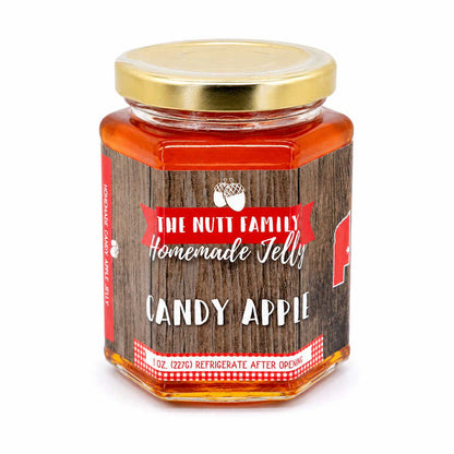 Jar of candy apple jelly with a wooden label on a white background