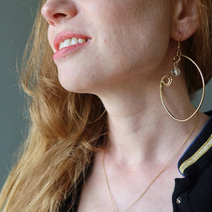 female model wearing Clear Quartz Wrap of Curved Gold Hoop Earrings