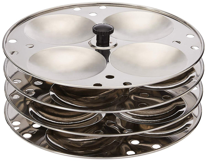 A four-tiered stainless steel idli stand with concave depressions on each tier for making idlis.