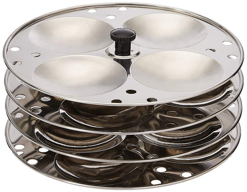 A four-tiered stainless steel idli stand with concave depressions on each tier for making idlis.